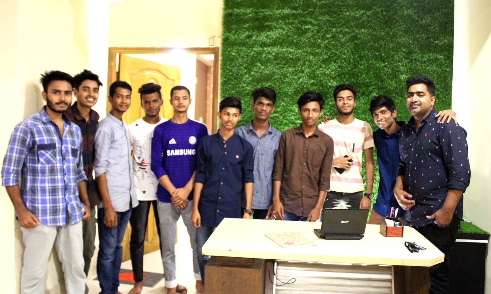A group of people standing together for a photograph in the office.