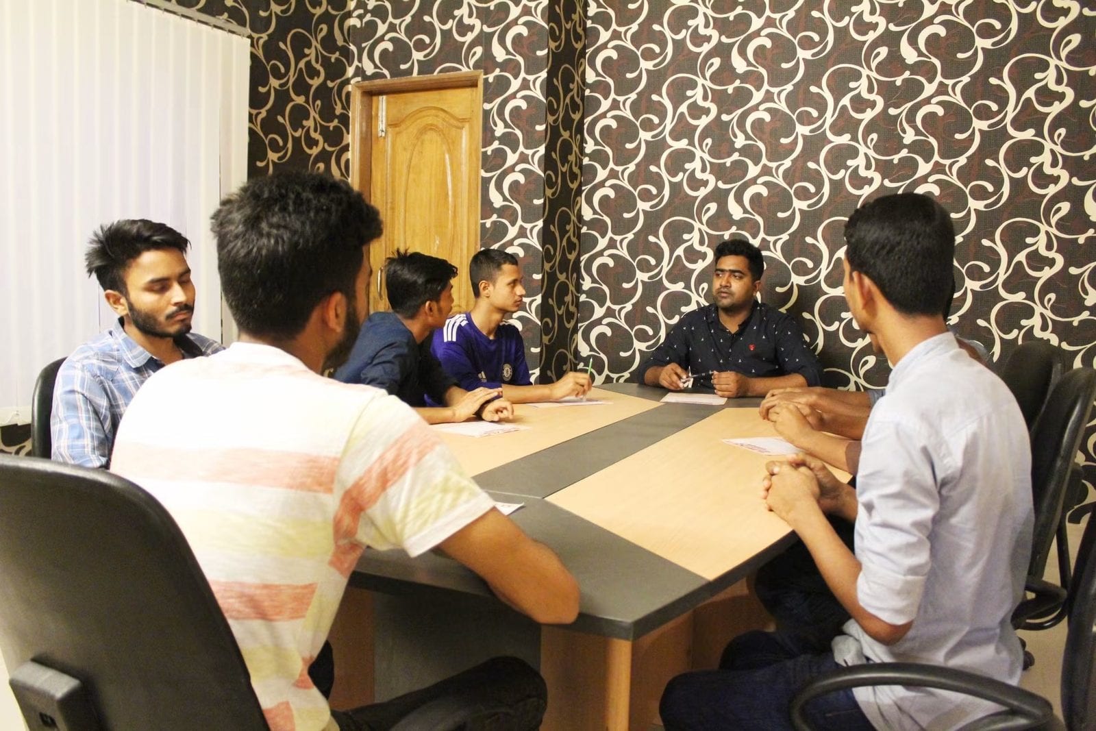 People seated around a meeting table.
