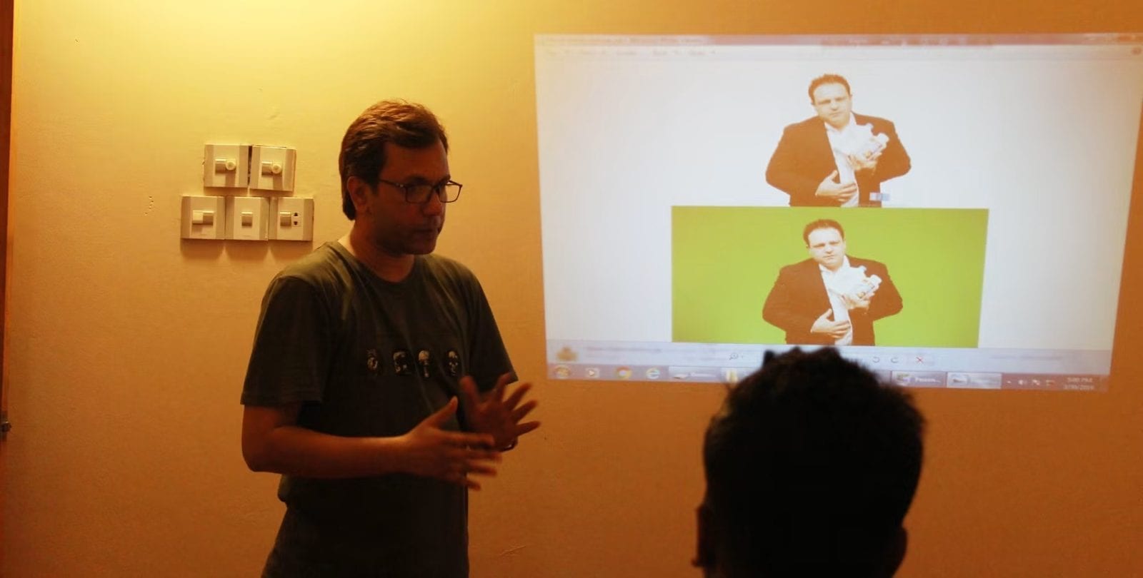 An instructor teaching in front of a projected screen.